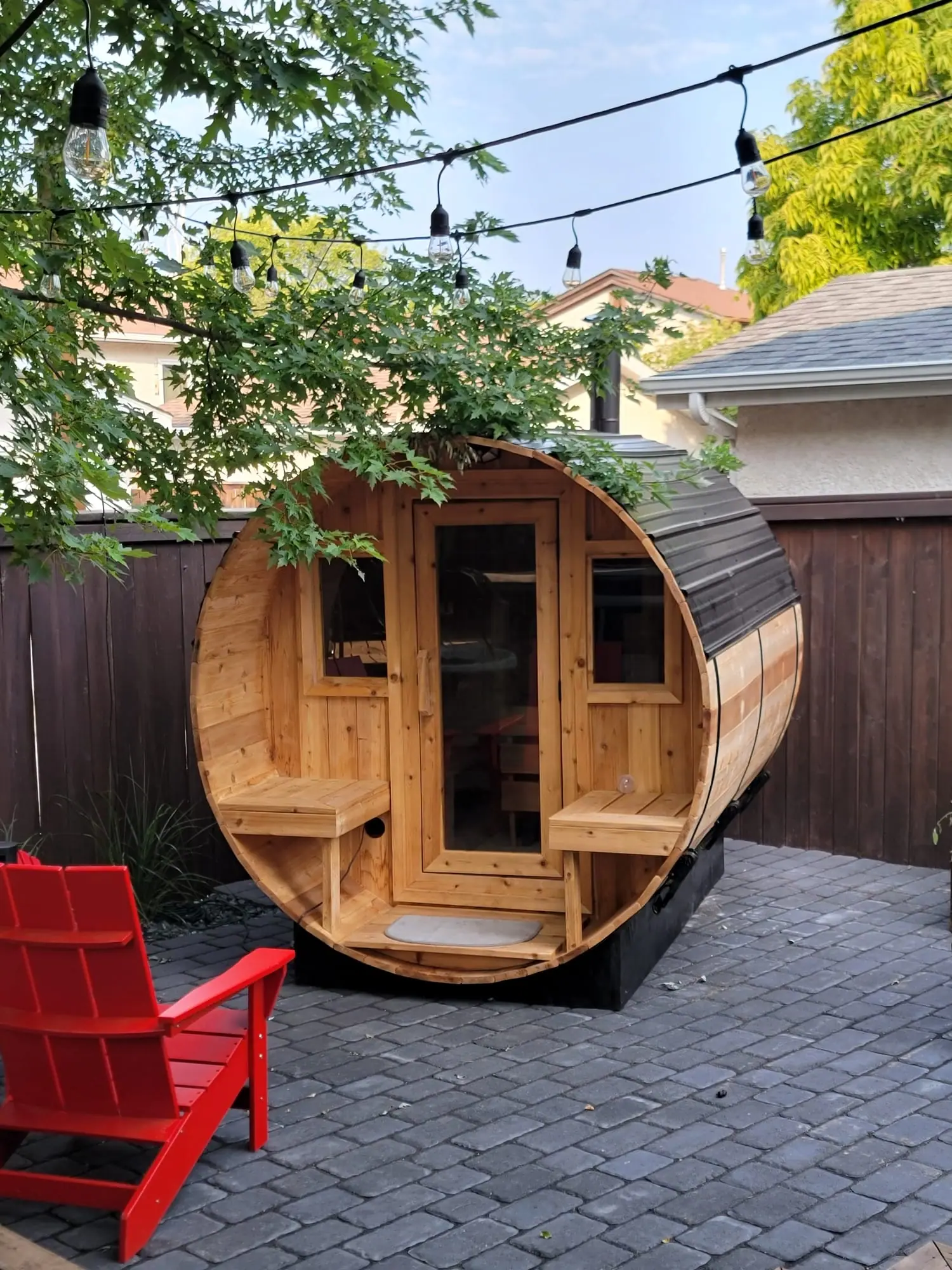 Cedar barrel sauna on a patio under string lights