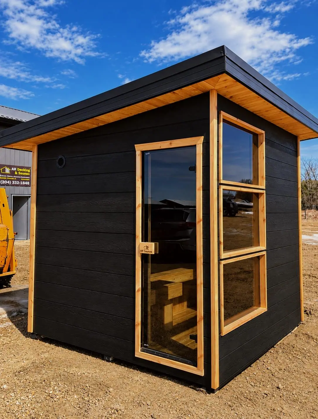 Black-sided cube sauna with cedar trim and tall windows