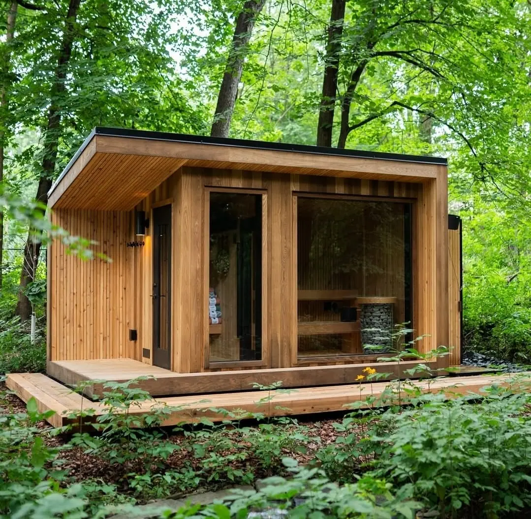 Cedar cube sauna with glass front in a forest