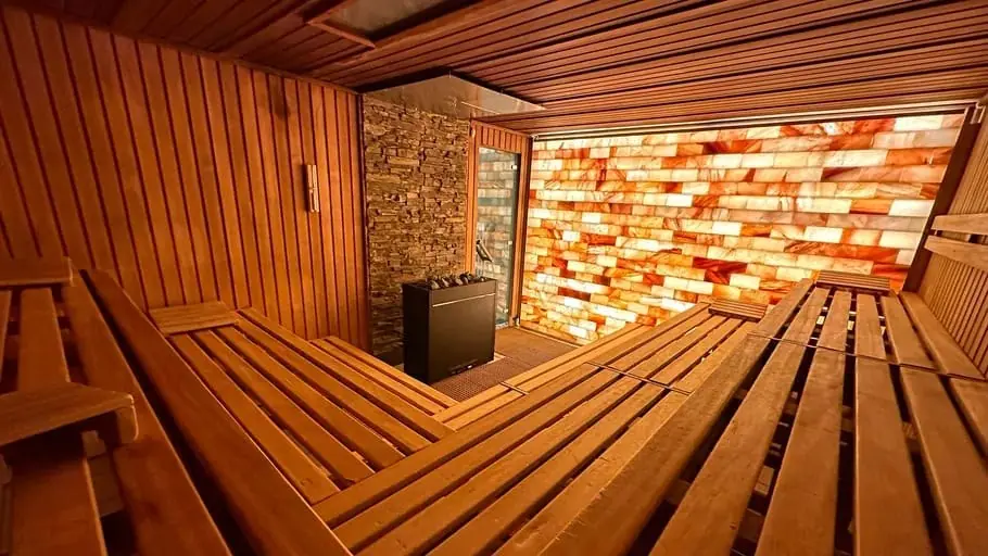 Custom sauna interior with a lit salt-brick wall