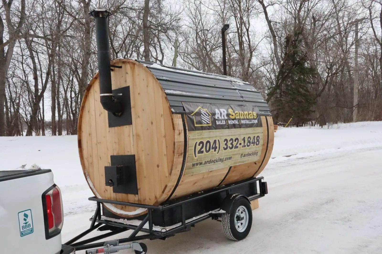Barrel sauna rental parked in the snow