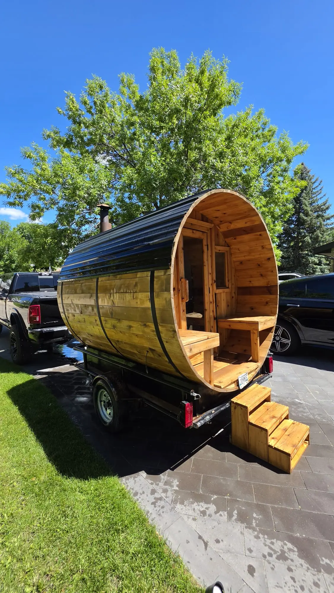 Rental barrel sauna on its trailer in a driveway