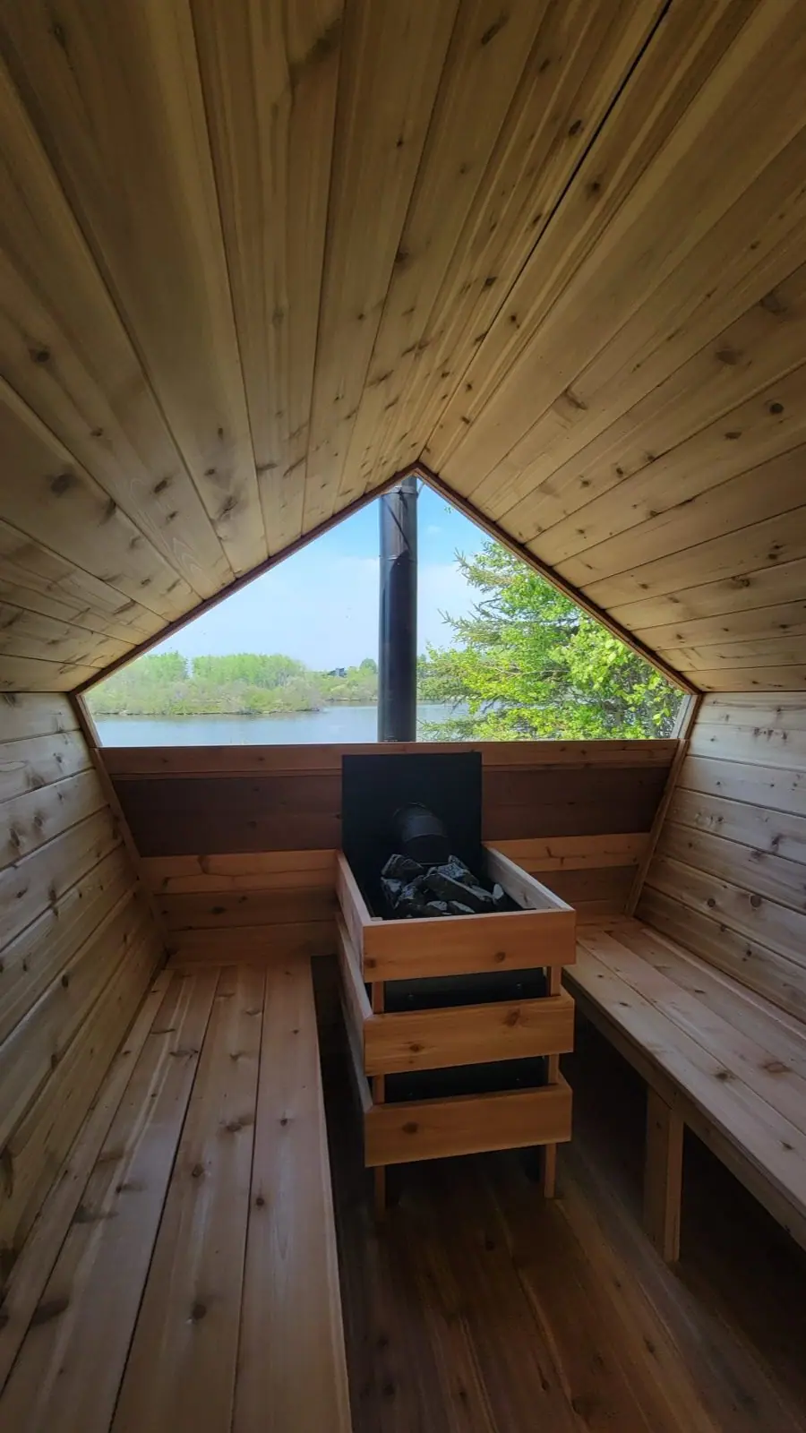 Inside a pentagon sauna looking out at the lake