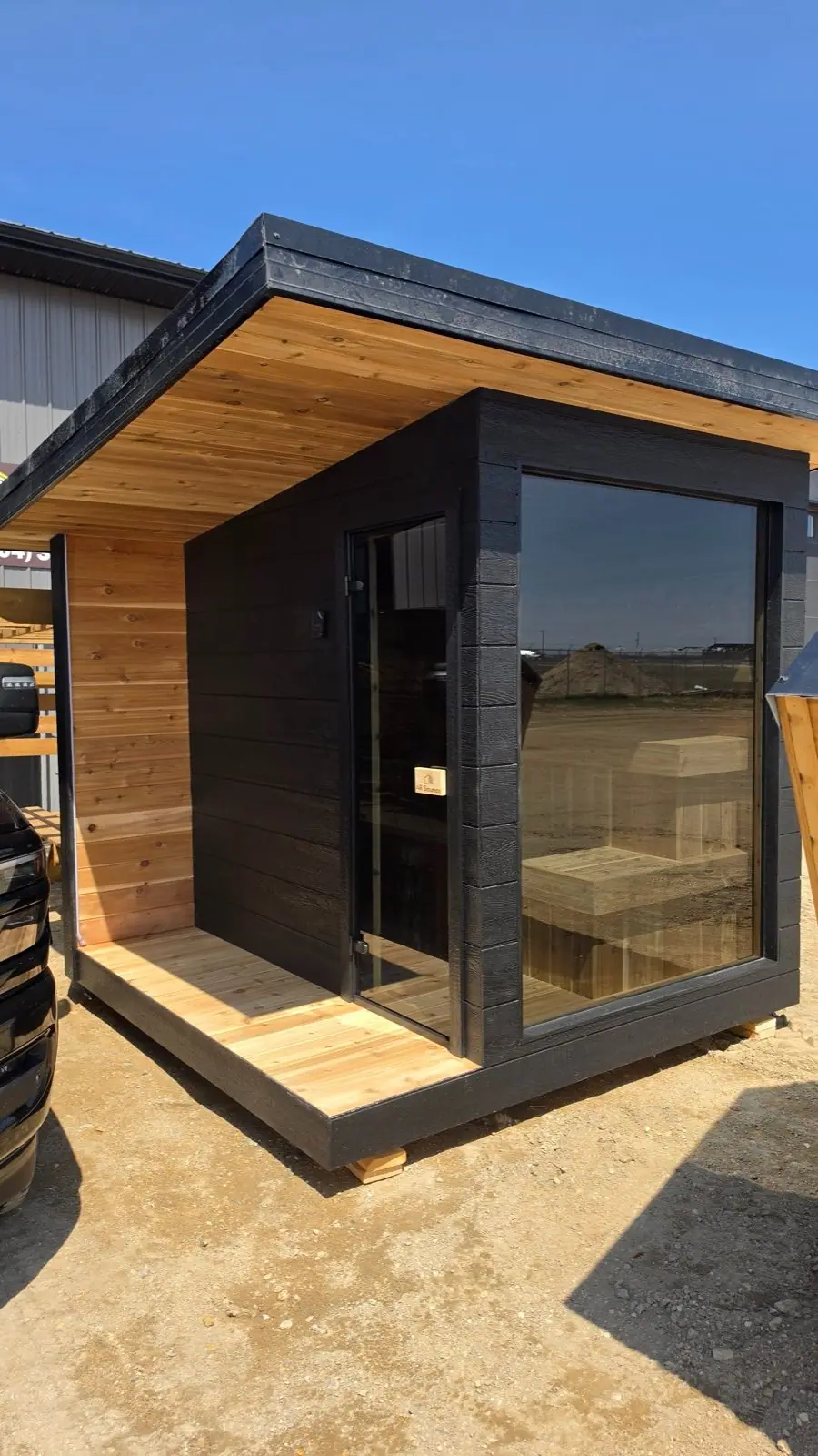 Black cube sauna with cedar accents
