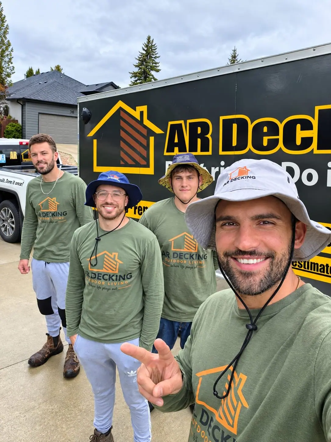 The crew on a job site beside the AR Decking trailer